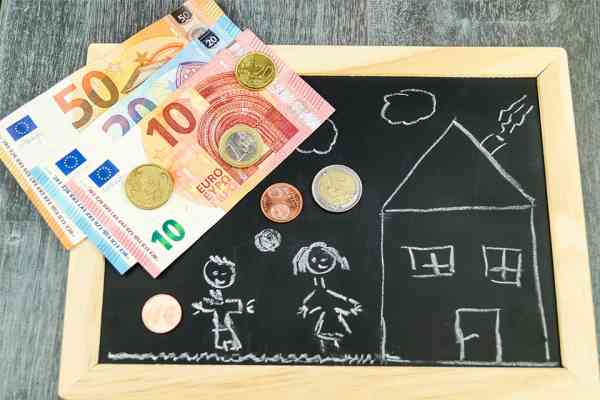 Tafel mit Kinderzeichnung darauf und Bargeld